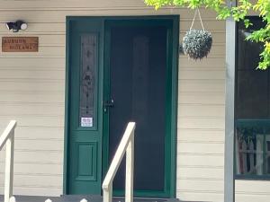 una porta verde sul lato di una casa di Auburn Hideaway ad Auburn