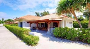a house with a porch and a palm tree at Nature Miraikan in Naha