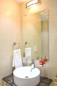 y baño con lavabo blanco y espejo. en Hotel Tara Palace Redfort en Nueva Delhi