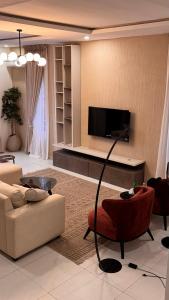 a living room with a couch and a flat screen tv at CrystalsLodge in Ibeju