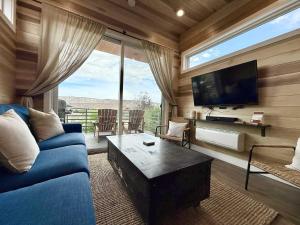 a living room with a blue couch and a tv at Escalante Escapes Prickly Pear- Bunk Escape in Escalante