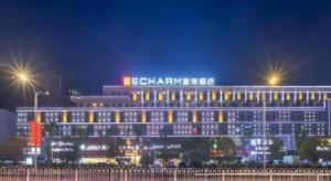 a large building with lights on it at night at Echarm Hotel Enshi Cultural Center Xintiandi in Enshi