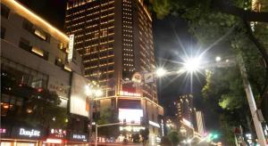 a city street at night with buildings and a street light at Echarm Hotel Changde Taoyuan Walking Street Jinyuan Tower in Changde