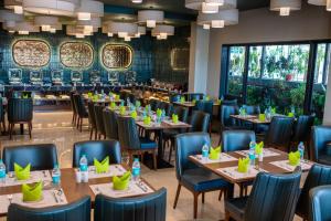 a row of tables and chairs in a restaurant at Masara Biznotel in Chakan