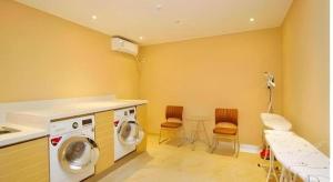 a laundry room with a washing machine and chairs at City Comfort Inn Zhanjiang Xuwen Port Wharf Chengdong in Xuwen +68 photos