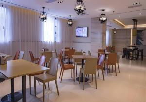 a restaurant with tables and chairs and a tv at City Comfort Inn Hainan Tunchang Changsheng Road 
