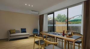 a living room with a table and chairs and a couch at City Comfort Inn Liuzhou Wuling Liutai Road in Liuzhou