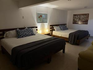 a hotel room with two beds and a couch at Casa el Refugio de las Flores in Oaxtepec +11 photos