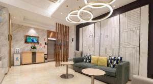 a living room with a couch and a table at City Comfort Inn Huangshi Daye Tongluowan Business Street in Huangshi