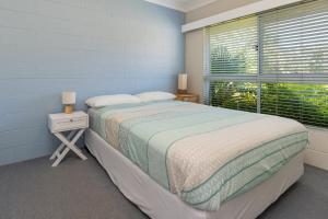ブルーイーズ・ビーチにあるBlueys Beach Villa Manyana 25の大きなベッドと窓のある寝室