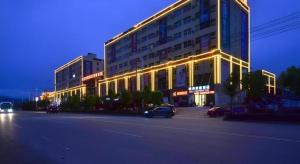 a lit up building on a city street at night at City Comfort Inn Lichuan Railway Station Jimi Home in Enshi