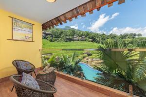 a room with a balcony with a view of a resort at Pu Luong EcoLuxe Resort & Spa in Lũng Tiềm
