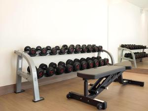 a gym with a rack of dumbbells on a wall at B2 Amata Nakorn Premier Hotel in Si Racha