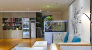 a living room with a couch and a refrigerator at 7 Days Premium Xianning Wenquan Shopping Center in Xianning