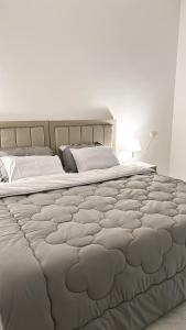 a large bed in a white room with at شقه مميزه بغرفة نوم وصالة واسعه in Hafr Al Baten