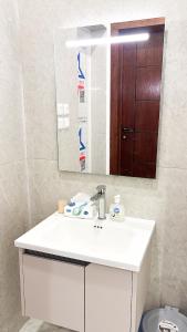 a bathroom with a white sink and a mirror at شقه مميزه بغرفة نوم وصالة واسعه in Hafr Al Baten