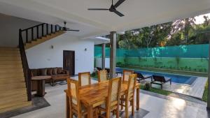a dining room with a table and chairs and a pool at Ima villa in Tangalle