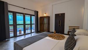 a bedroom with a large bed with a large window at Ima villa in Tangalle