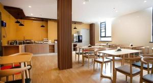 a restaurant with tables and chairs and a kitchen at GreenTree Inn Linhai Jiangnan Avenue Express in Linhai
