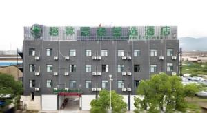 a large gray building with green and white windows at GreenTree Inn Linhai Jiangnan Avenue Express in Linhai