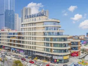 un grand bâtiment dans une ville avec de la circulation devant lui dans l'établissement Gya Hotel Nantong Nanshang Lake Street Wanda Plaza, à Nantong