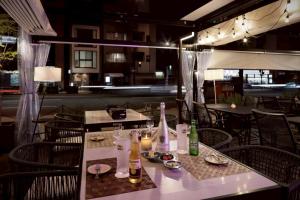 un restaurant avec des tables et des chaises, des bouteilles et des bougies dans l'établissement Doutonbori Crystal Exe, à Osaka