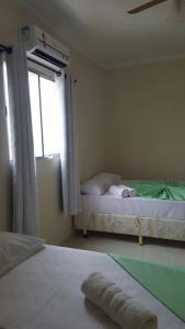 um quarto com 2 camas e uma janela em Hotel Pousada do Papa em Aparecida