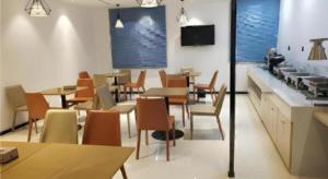 un restaurant avec des tables et des chaises dans une salle dans l'établissement City Comfort Inn Yongzhou Xiaoxiang Bridge Xinhua Bookstore, à Guzhuting