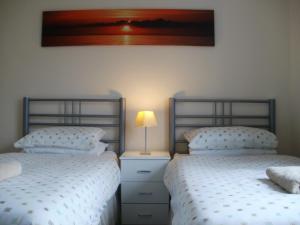 dos camas sentadas una al lado de la otra en un dormitorio en London Heathrow Guesthouse, en Hillingdon