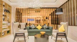 a living room with a green couch and chairs at City Comfort Inn Kunshan Development Zone Penglang Xinxing Middle Road in Suzhou
