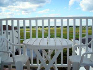 uma mesa branca e cadeiras numa varanda branca em Atlantic Breeze Suites em Hampton