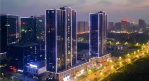 a city skyline with tall buildings at night at Borrman Hotel Jining Rencheng District Government Zhongde Plaza in Jining