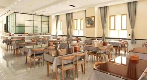 a restaurant with tables and chairs in a room at GreenTree Inn Xinjiang Kashgar Food Street in Kashgar