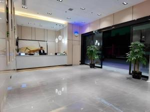 a lobby of a building with a man in the background at GreenTree Inn Express Fuzhou Linchuan District Gandong Auto City in Fuzhou