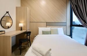 a bedroom with a bed and a desk and a mirror at DeOrient - deLofts Emporium 8Pax - VH17 in Kuching