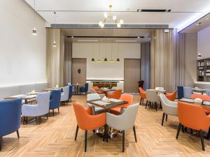 a restaurant with tables and chairs and a whiteboard at Echarm Hotel Fangchenggang Qisha in Fangcheng