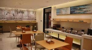 a restaurant with tables and chairs and a counter at City Comfort Inn Wuhan Changfeng Avenue 3rd Hanxi Road in Wuhan