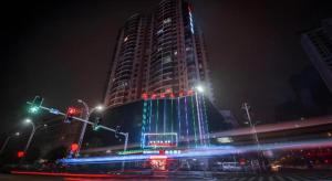 a tall building with lights on it at night at Borrman Hotel Yongzhou High Speed Railway Station in Guzhuting