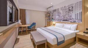 ein Hotelzimmer mit einem großen Bett und einem TV in der Unterkunft City Comfort Inn Fangchenggang Government Affairs Center in Fangchenggang + 215 Fotos