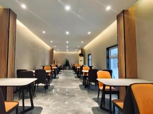 a row of tables and chairs in a restaurant at Shell Hotel Shandong Jinan Daming Lake in Jinan