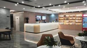 a salon with a reception desk and chairs and tables at Shell Hotel Shandong Jinan Daming Lake in Jinan