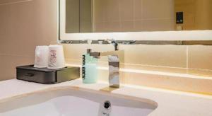a bathroom counter with a sink and a mirror at City Comfort Inn Qingyuan Fogang Coach Terminal in Qingyuan +154 photos