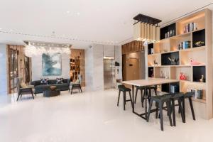 ein Wohnzimmer mit Tisch und Stühlen und einer Couch in der Unterkunft City Comfort Inn Fangchenggang Qisha in Fangchenggang