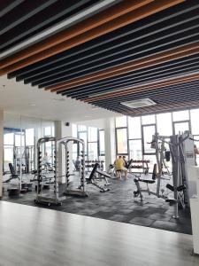 a gym with several tread machines and people in the background at K Avenue Lucky Stay Suite in Penampang