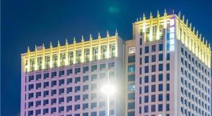 a large white building with a light on top of it at Echarm Hotel Suzhou Shengze Oriental Extile City in Suzhou
