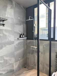 a bathroom with a shower with a glass door at MAIA Hotel & Apartment Danang in Da Nang +87 photos