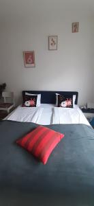 a bed with a red pillow on top of it at Wonderful Stay Helsingborg in Helsingborg