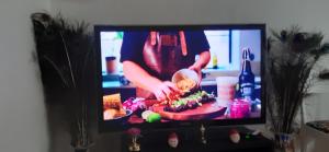 a tv screen with a person cutting a cake at Wonderful Stay Helsingborg in Helsingborg