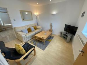 a living room with a couch and a table at Earle House Serviced Apartments in Crewe