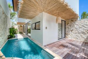 Anjuna Surf & Sunset 2BR Villas in Uluwatu في أُلُواتو: مسبح في بيت بسقف